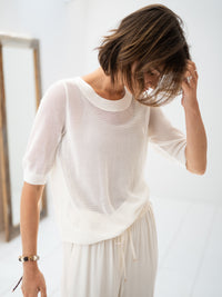 PLEIN PUBLIQUE white mesh sweater with silk, shown indoors on a model touching her hair.