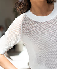 Short-sleeved white mesh sweater with silk, shown in bright natural light.
