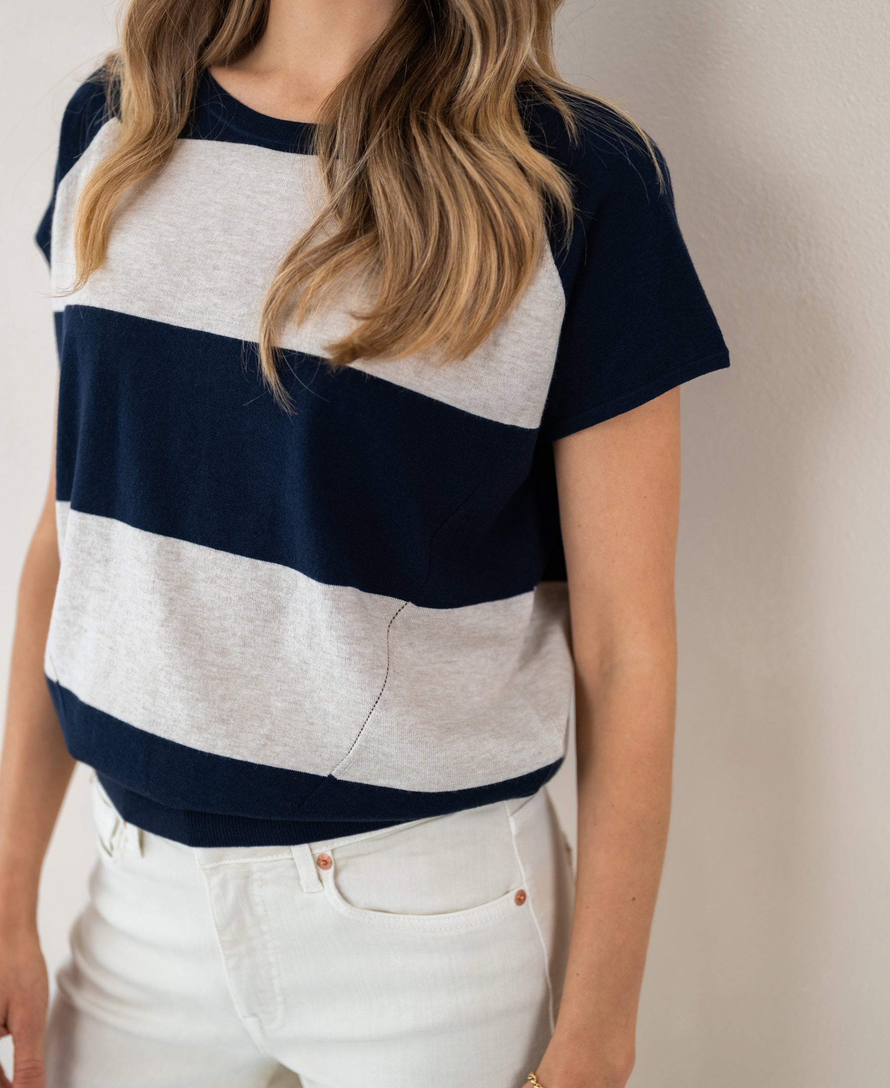 Woman wearing a PLEIN PUBLIQUE striped sweater LA PALOISE in dark blue and sand.