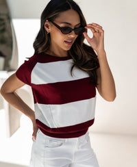Woman wearing the PLEIN PUBLIQUE LA PALOISE striped wine-ivory sweater, hand on hip.