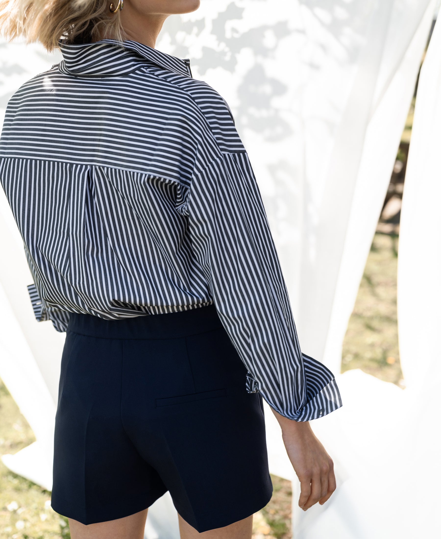 Navy blue PLEIN PUBLIQUE LA MADDY shorts, worn outdoors for a breezy summer vibe.