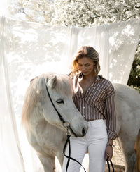 Tencel blouse in brown and ivory, shown outdoors in front of draped fabric.