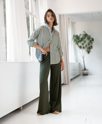 PLEIN PUBLIQUE LA PASCALLE blouse, white and olive green striped, shown in a modern setting.