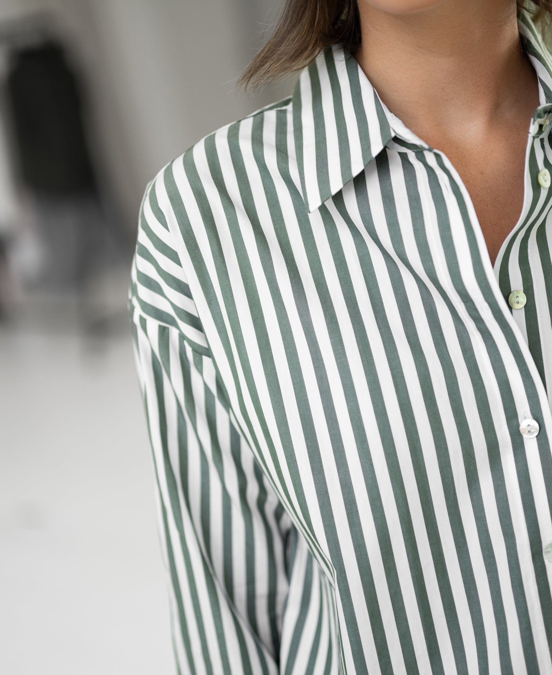 The PLEIN PUBLIQUE LA PASCALLE blouse in white and olive-green stripes, shown from the shoulders down.