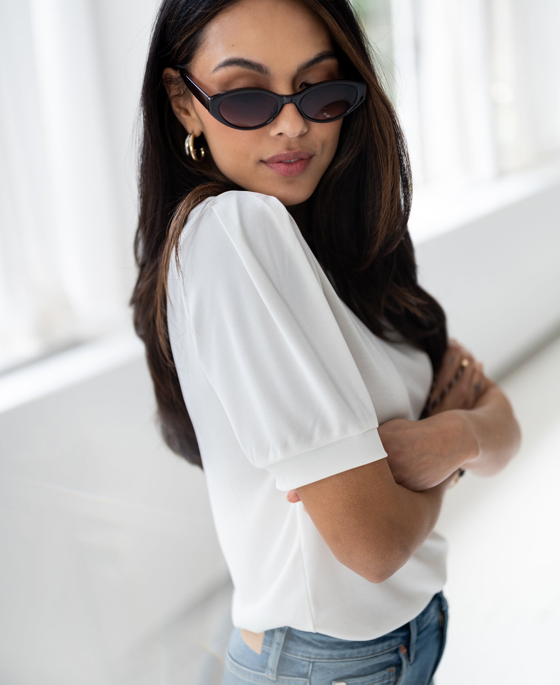 Woman wearing ivory ribbed T-shirt in a modern space.