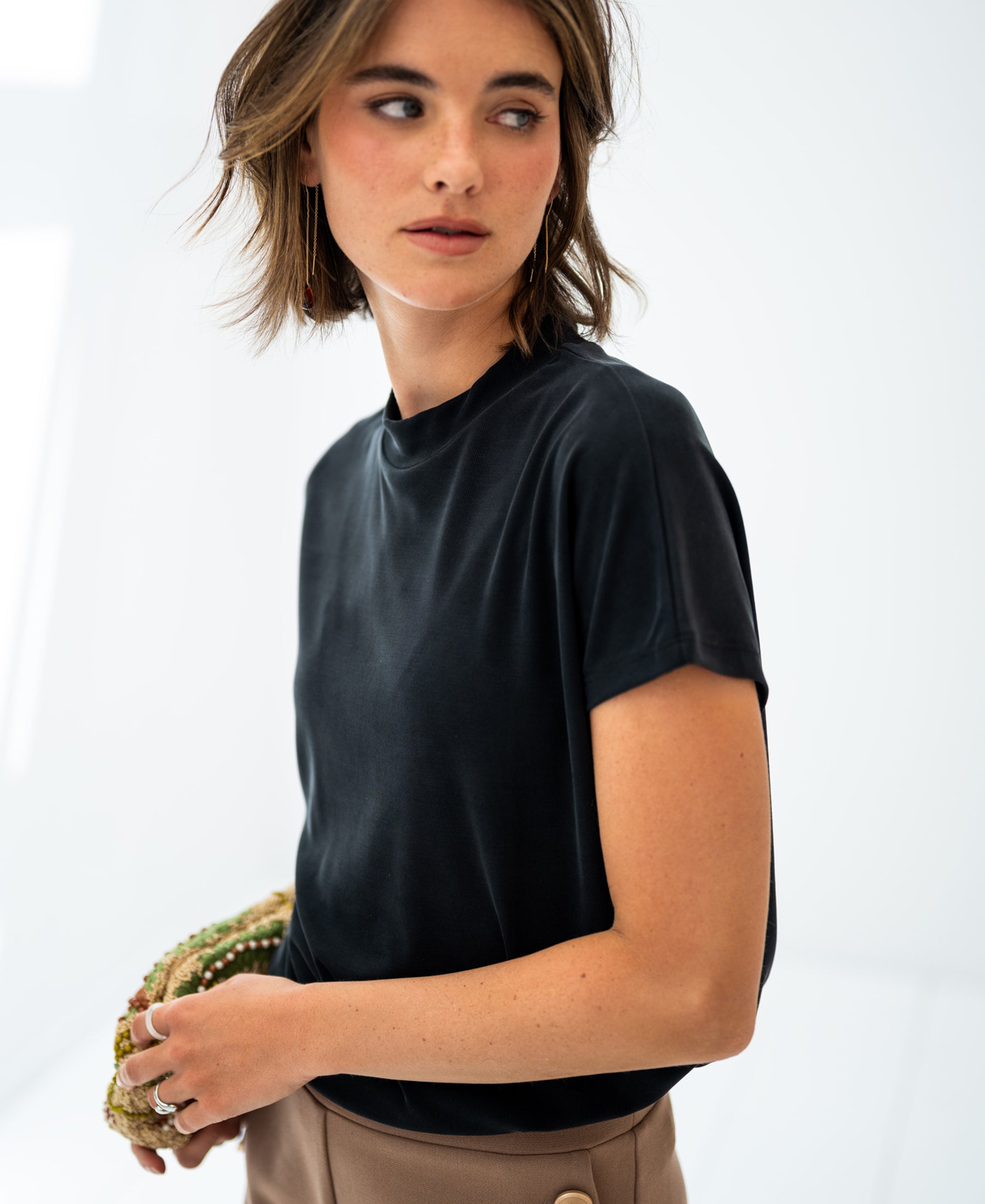 Charcoal ribbed top in a fitted style, shown on a woman looking to the side.