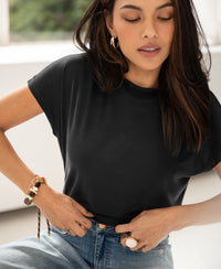 Woman wearing a ribbed charcoal gray top with a high collar indoors.