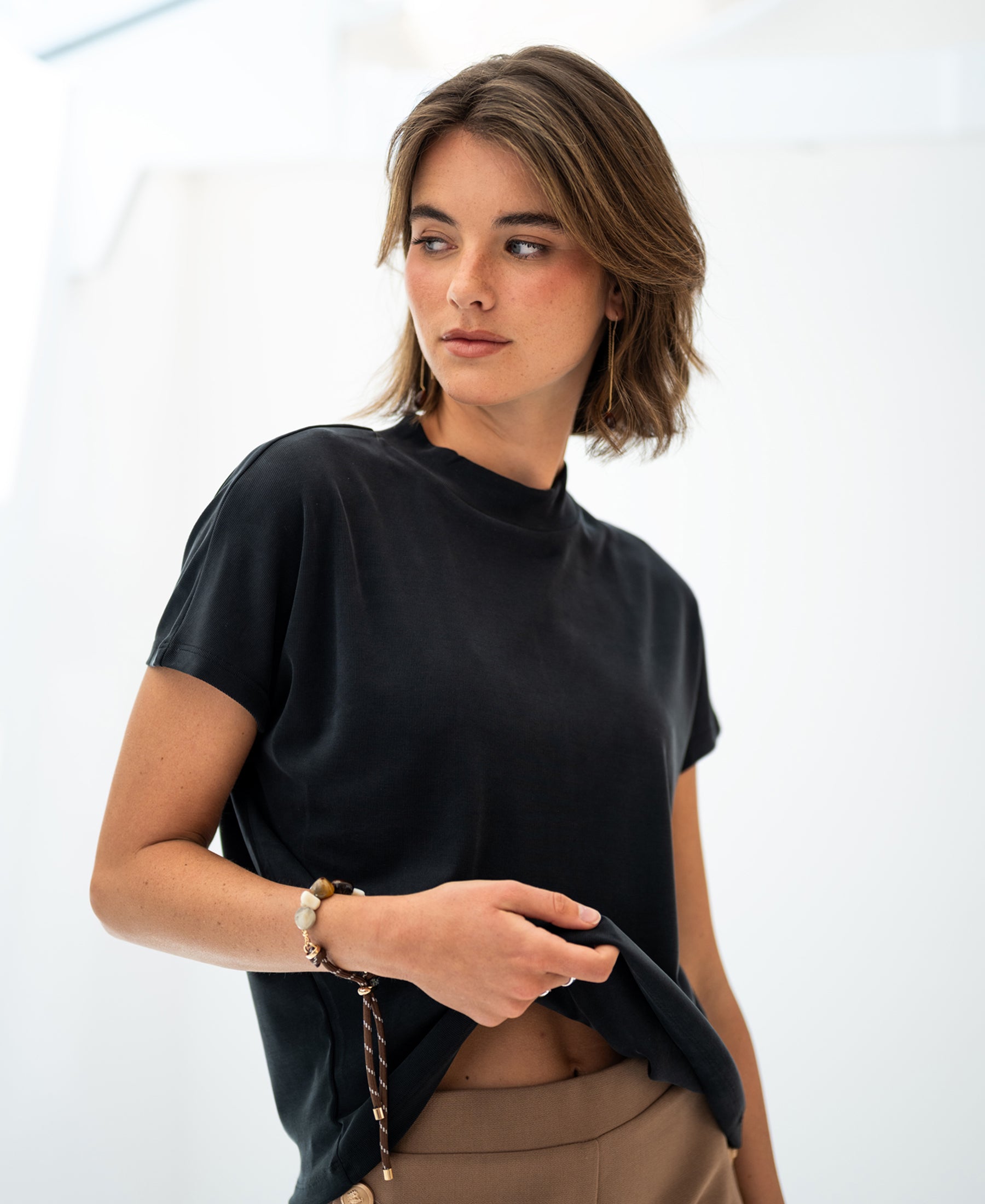 Charcoal ribbed collared top in cotton blend, shown from the side against a bright background.