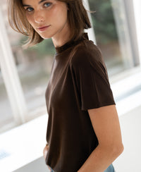 Brown ribbed collared top in chocolate color shown indoors near large bright windows.