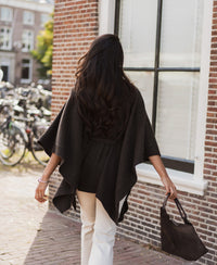 Woman wearing a chocolate brown merino wool poncho.