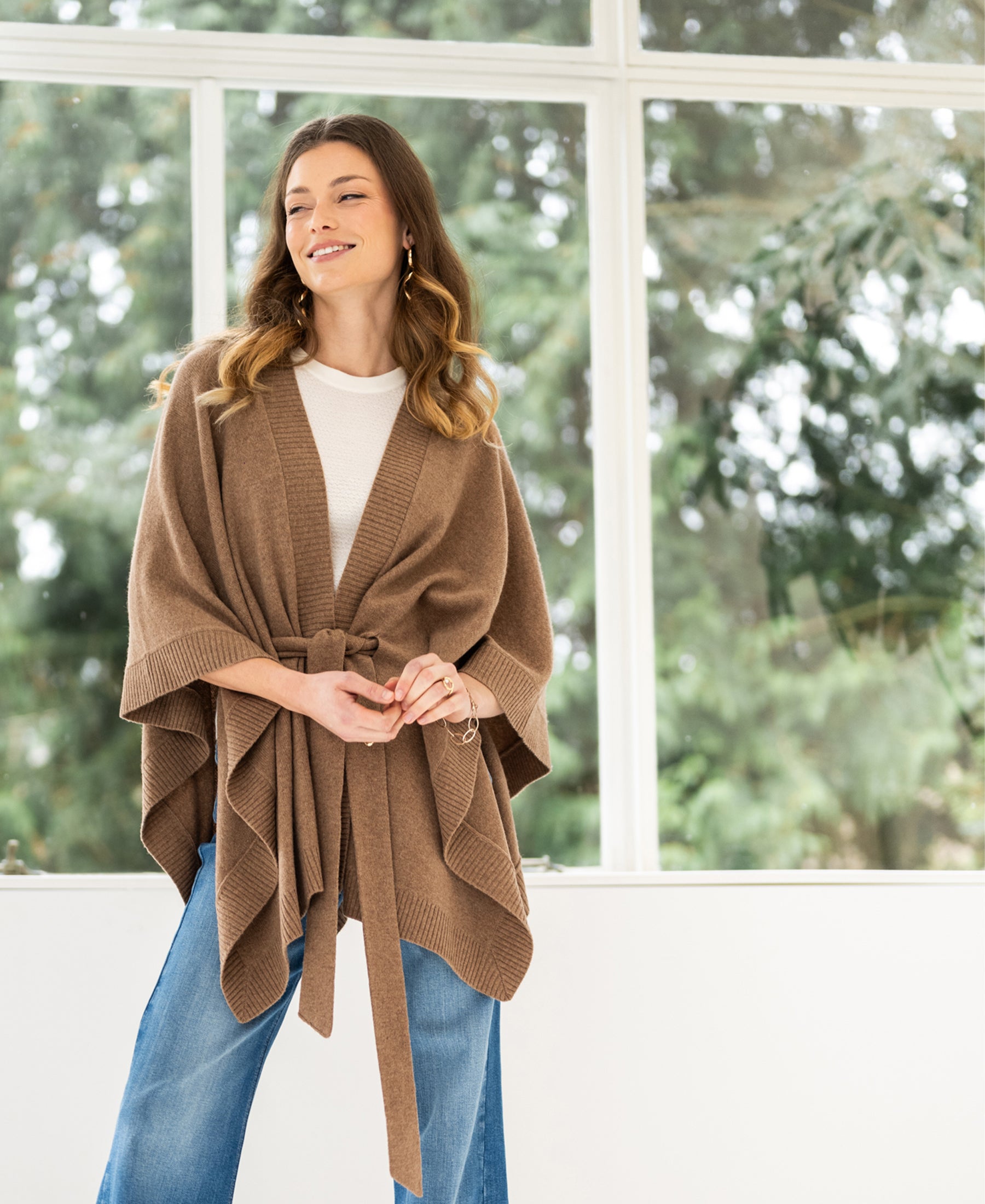 Camel-colored merino wool poncho shown.