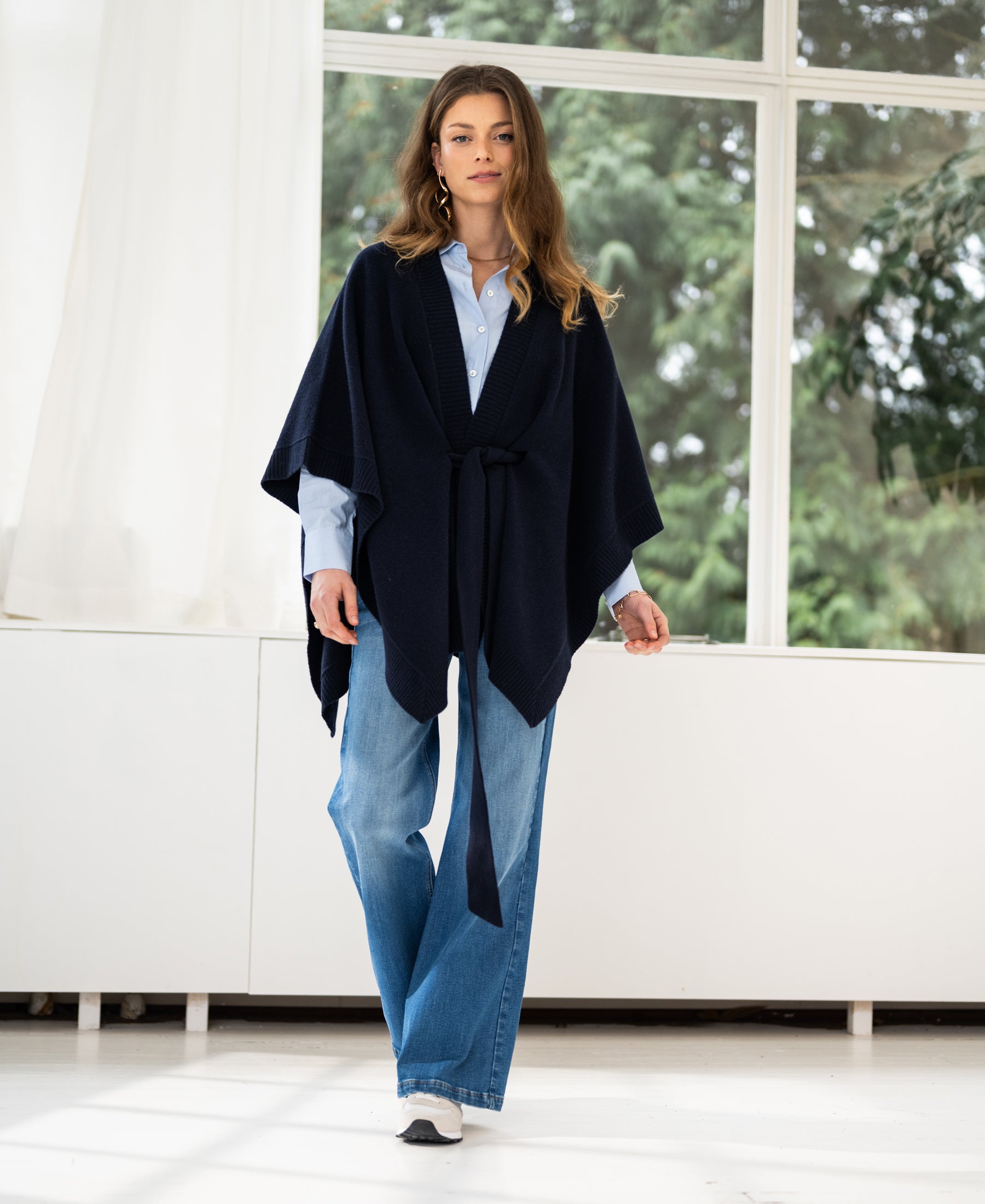 Navy blue merino wool poncho shown indoors.