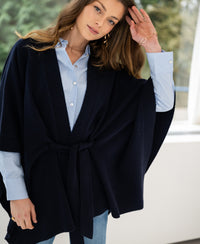 Navy blue merino wool poncho shown indoors.