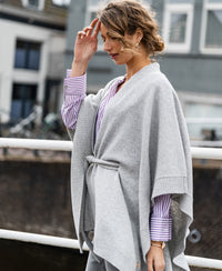 Light grey merino wool poncho by PLEIN PUBLIQUE shown outdoors.