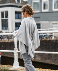 Woman wearing a Plein Publique merino wool poncho in silver gray.
