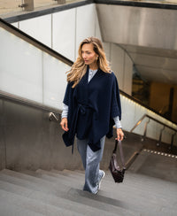 Dark blue merino wool poncho by PLEIN PUBLIQUE, shown from the front.