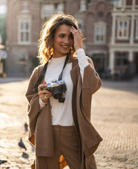 Camel-colored merino wool poncho shown in sunlight.