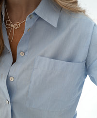 Woman wearing PLEIN PUBLIQUE LA PASCALLE light blue striped blouse.