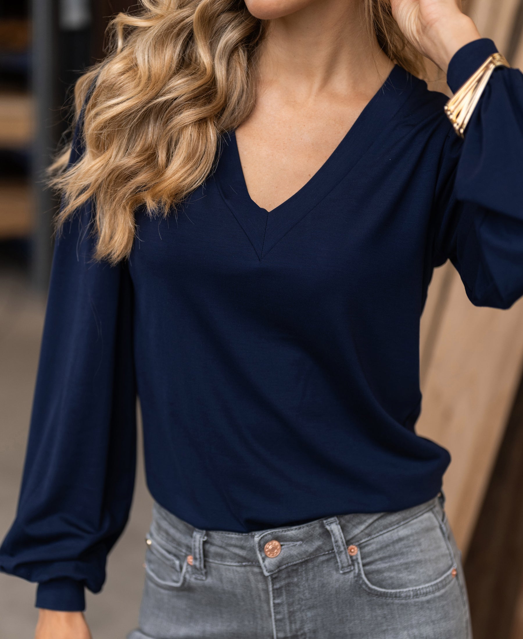 Woman wearing a Plein Publique LA LIANA V-neck top in dark blue.