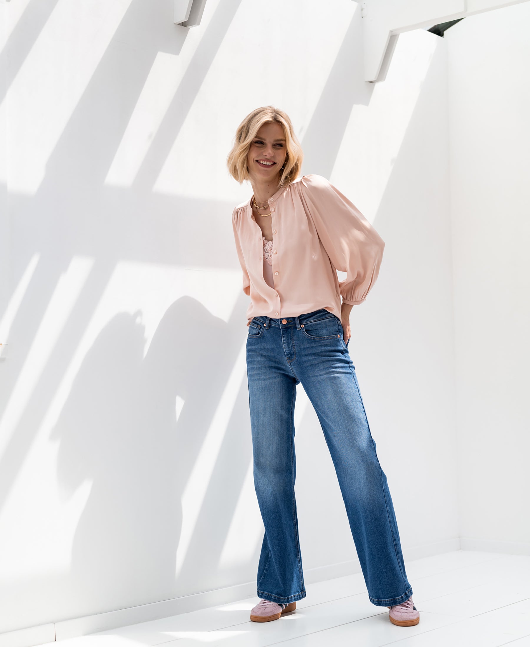 Wide leg stonewash jeans in a bright, sunlit room.