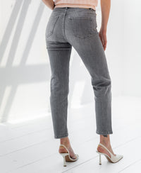 Grey stonewash cropped jeans in a back view, shown on a white floor.