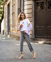 Grey stonewash cropped jeans in a classic fit, shown outdoors on a cobblestone street.