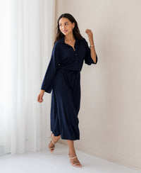 PLEIN PUBLIQUE LE RAPHAEL dark blue button-down dress shown indoors by a light wall.