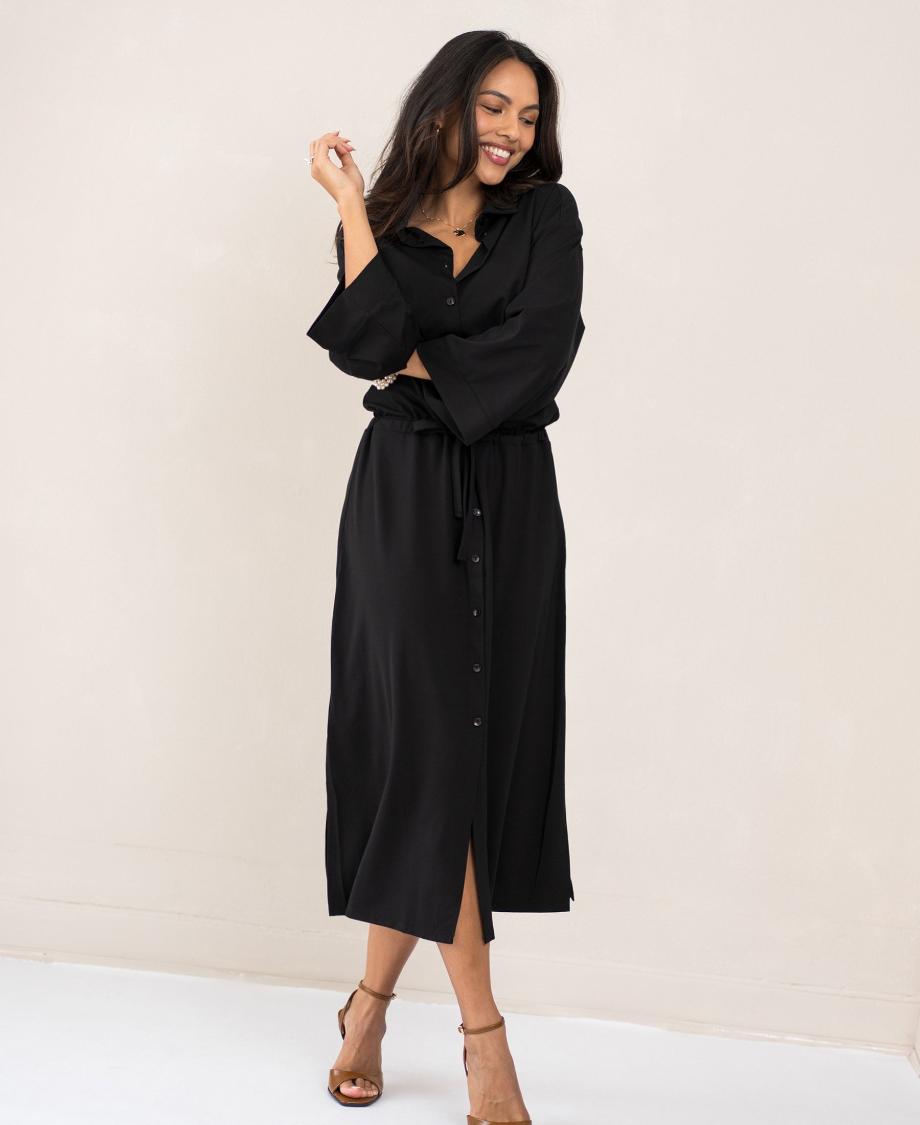 Front view of woman in the LE RAPHAEL Black Button-Down Dress by PLEIN PUBLIQUE, standing indoors.