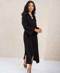 Black button-down dress by PLEIN PUBLIQUE displayed in a minimal, light-toned room.