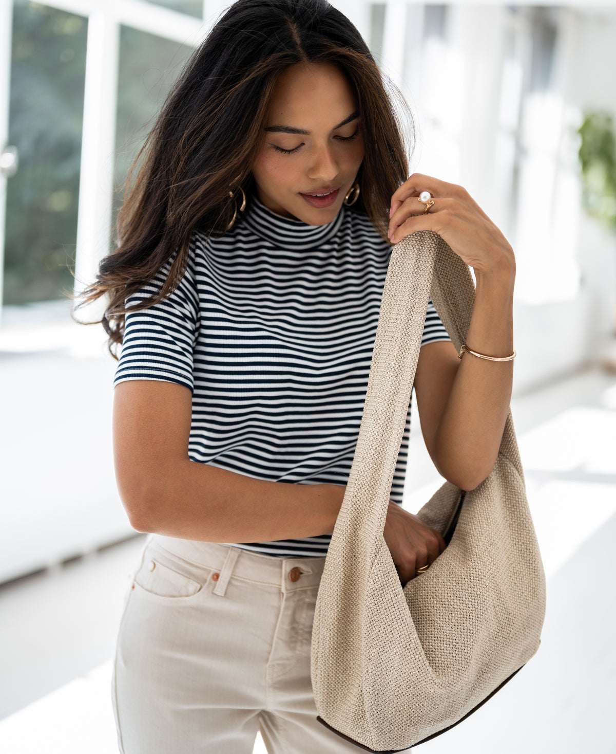 Navy and white ribbed top from Plein Publique, shown worn by a woman in a sunlit room.