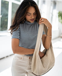 Navy and white ribbed top from Plein Publique, shown worn by a woman in a sunlit room.