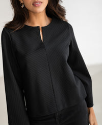 Black pinstripe LE SAINT top by PLEIN PUBLIQUE, shown from shoulders to hips.