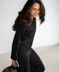 Black LE SAINT Pinstripe Top by PLEIN PUBLIQUE shown against a light, blurred background.