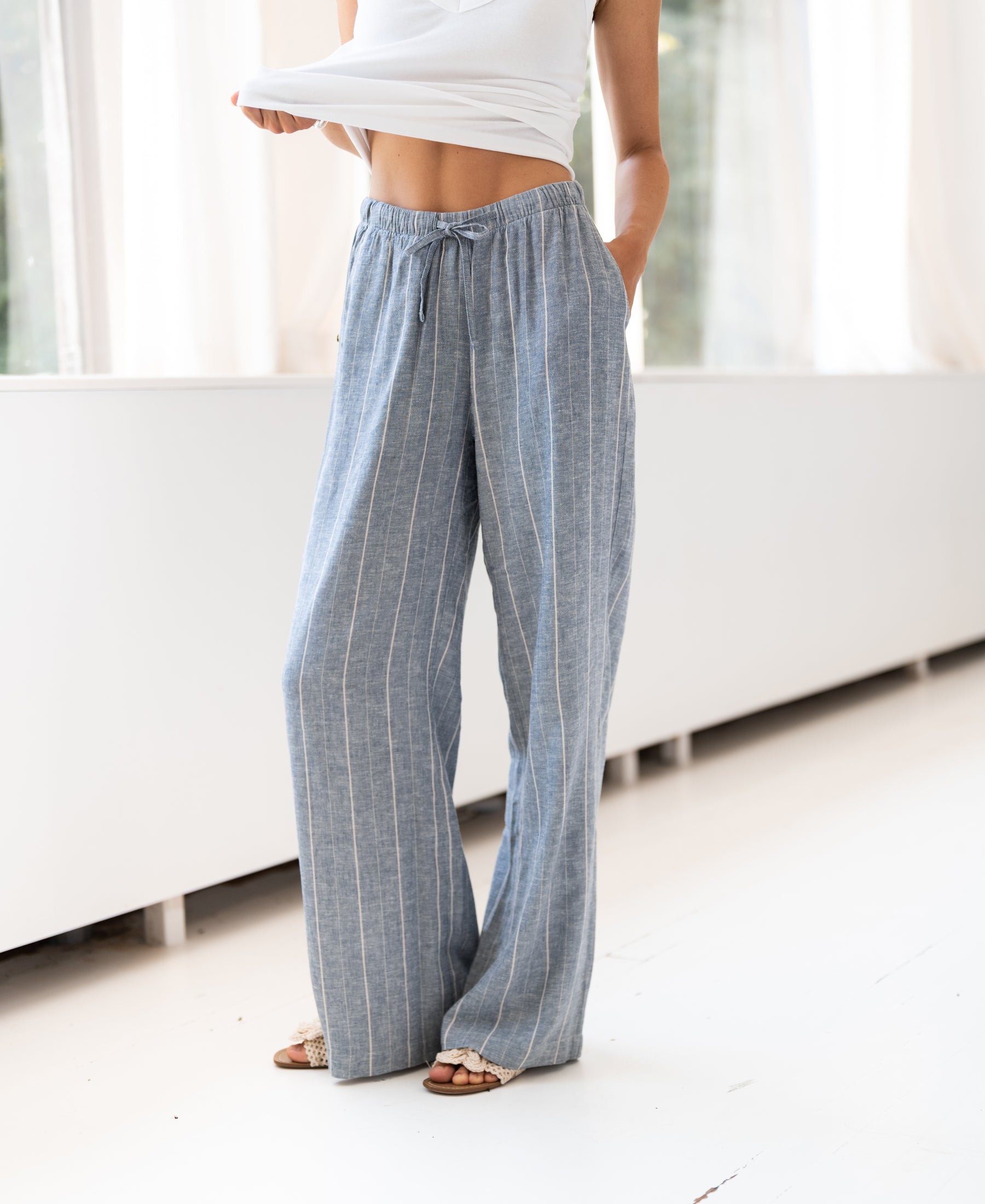 LA SECONDE striped linen-blend trousers by PLEIN PUBLIQUE in denim blue, waistband visible.