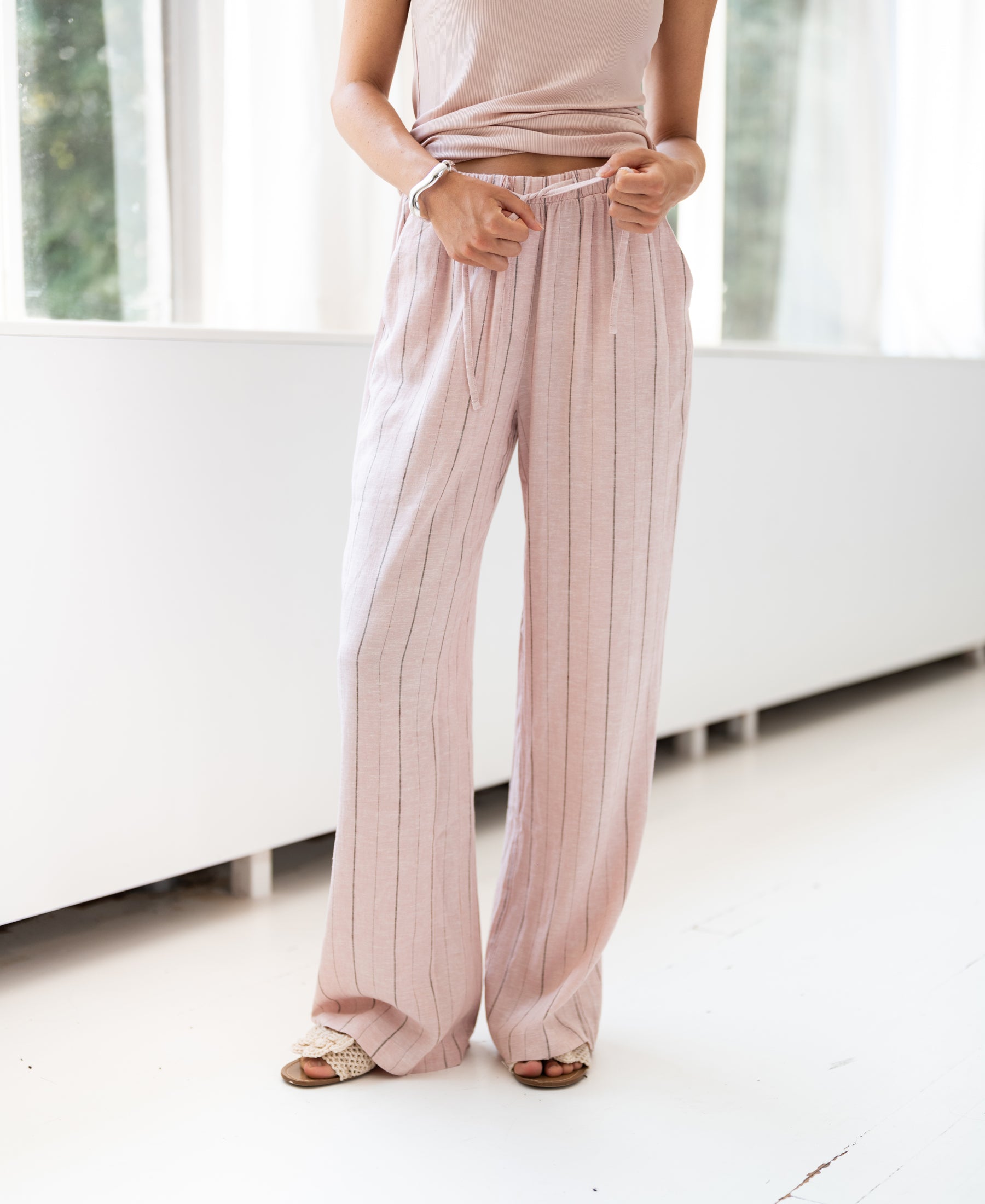 Gestreepte linnenblend broek LA SECONDE Pink van PLEIN PUBLIQUE, handen in haar zakken.