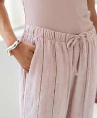 Person wearing pink striped linen-blend trousers by PLEIN PUBLIQUE, front view.
