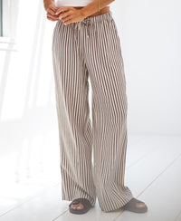 Person wearing PLEIN PUBLIQUE striped linen-blend pants LA SECONDE Brown.