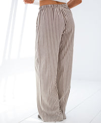 Brown striped linen-blend trousers on a white floor.