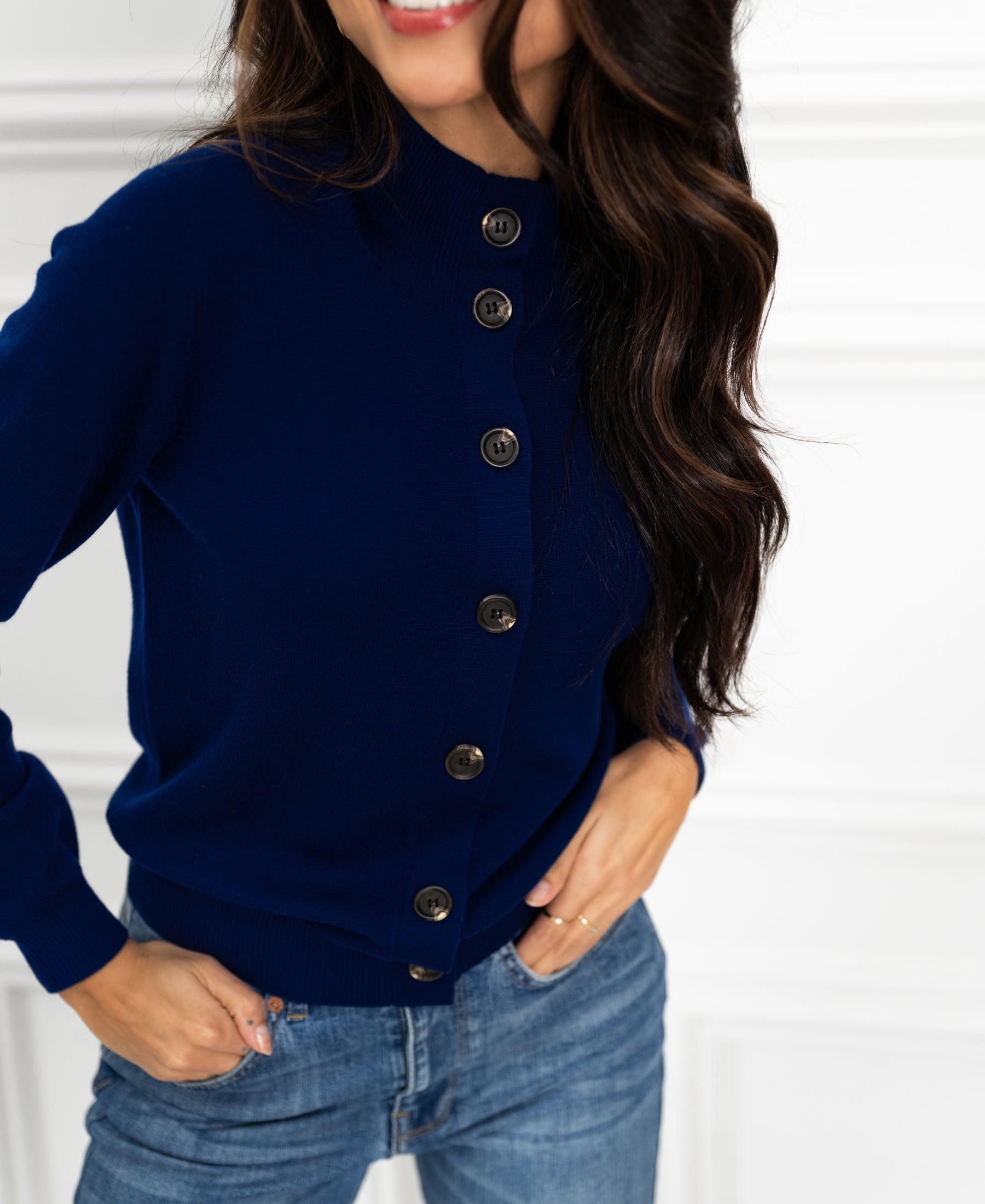 Navy blue Merino wool turtleneck vest by PLEIN PUBLIQUE, shown on a model with a hand on her hip.