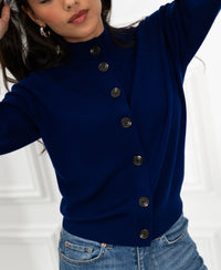 Navy blue merino turtleneck cardigan by PLEIN PUBLIQUE, shown on model with arms raised against a white background.