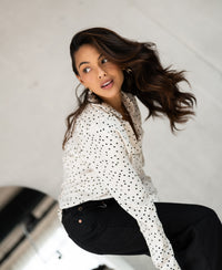 Ivory-black polka dot blouse by PLEIN PUBLIQUE, LA SEZANNE style, shown from the back indoors.