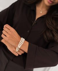Woman wearing the PLEIN PUBLIQUE Silverse travel blouse in pure chocolate brown adjusts her sleeve.