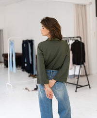 Olive green LA SILVESE travel blouse by PLEIN PUBLIQUE shown worn by a woman.
