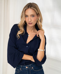 Woman wearing dark blue PLEIN PUBLIQUE LA SILVESE travel blouse, posing indoors.