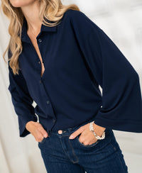 Woman wearing a dark blue LA SILVESE travel blouse by PLEIN PUBLIQUE.