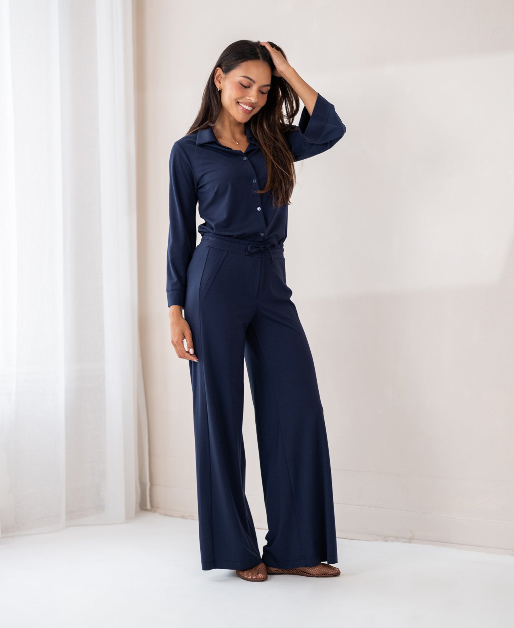 Woman wears PLEIN PUBLIQUE dark blue travel pants LA JULIA.