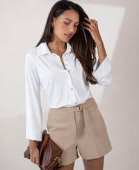 Woman wearing a white PLEIN PUBLIQUE travel blouse LA SILVESE stands against a neutral background.