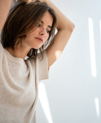 Light sand-colored linen summer sweater, PLEIN PUBLIQUE LE SOLEIL, shown with models arms raised in sunlight.