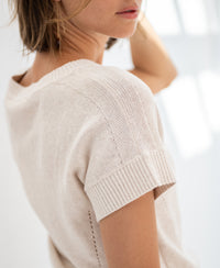 Linen summer sweater in light sand by PLEIN PUBLIQUE, shown from the side in soft natural light.