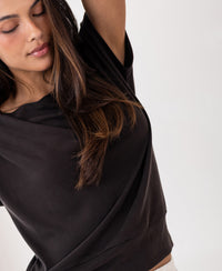 Brown ribbed boat neck T-shirt in pure chocolate color, shown on model with one arm raised.